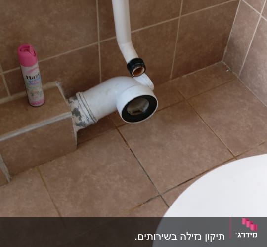 צינור ביוב פתוח ליד אסלה בשירותים